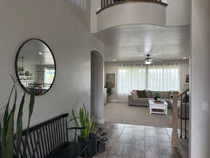 Corridor featuring arched walkways and wood finished floors