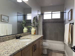 Bathroom with vanity, shower / tub combo, and wood finished floors