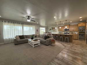 Living area featuring a textured ceiling, recessed lighting, and a ceiling fan