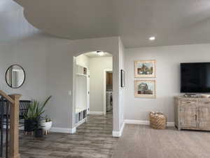 Living room with arched walkways, recessed lighting, a textured ceiling, stairs, and wood finished floors