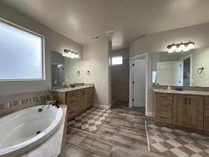 Full bath with a bath and two vanities
