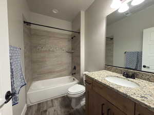 Full bath featuring shower / tub combination, vanity, and wood finished floors