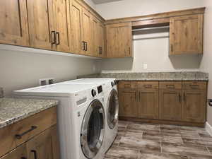 Laundry room featuring cabinet space, washer and dryer, and wood finish floors