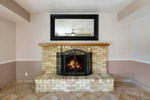 Detailed view of a ceiling fan and a brick fireplace