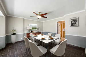 Dining room with ornamental molding, wood finish floors, and a ceiling fan