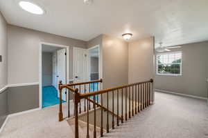 Corridor with an upstairs landing and carpet