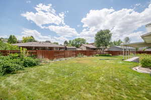 Fenced backyard featuring a residential view