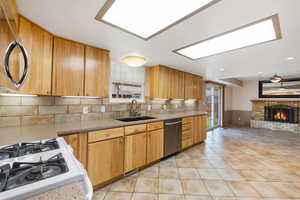 Kitchen with appliances with stainless steel finishes, tasteful backsplash, light countertops, and light tile patterned flooring