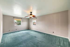 Empty room featuring carpet flooring and ceiling fan