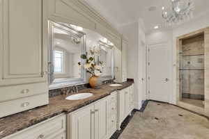 Bathroom with a chandelier, inlaid floor details, recessed lighting, a stall shower, and double vanity