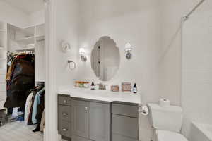 Bathroom with vanity, a spacious closet, and washtub / shower combination