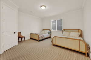 Carpeted bedroom with ornamental molding