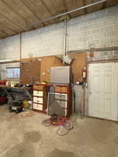 Garage featuring a workshop area and concrete block wall