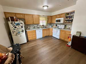 Kitchen with white appliances, light wood-type flooring, tasteful backsplash, a textured ceiling, and open shelves