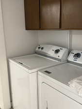 Laundry area with separate washer and dryer and cabinet space