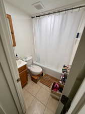 Full bathroom with shower / tub combo with curtain, vanity, and light tile patterned floors
