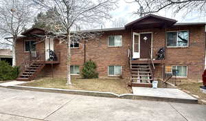 View of front of property with brick siding and stairs