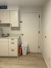 Kitchen with light countertops, light wood-type flooring, and light brown cabinetry