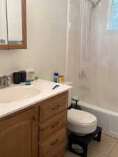 Full bath with vanity, tile patterned floors, and shower / bath combo with shower curtain