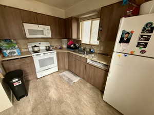 Kitchen with white appliances, light countertops, and light flooring