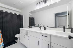 Full bath with toilet and double vanity