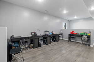Home office with a textured ceiling and wood finished floors