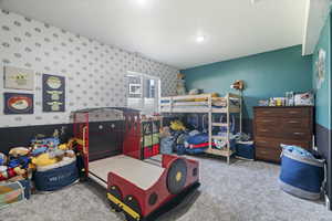 Bedroom with carpet floors and wallpapered walls