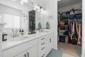 Full bath featuring double vanity and a spacious closet