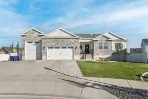 Craftsman-style home with a garage, driveway, a gate, and stone siding