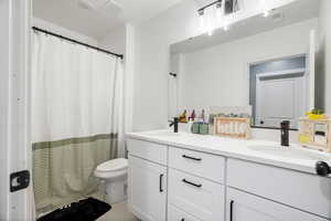 Bathroom featuring double vanity and a shower with curtain