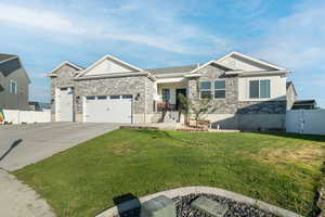 Craftsman-style house featuring an attached garage, concrete driveway, stone siding, and a gate