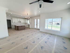 Kitchen with a chandelier, open floor plan, a kitchen island, french doors, and light countertops