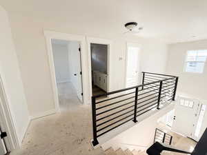 Corridor with an upstairs landing and baseboards