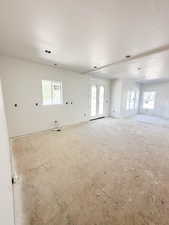 Unfurnished room with plenty of natural light, a textured ceiling, and french doors
