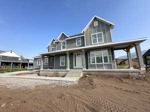View of front facade featuring covered porch and board and batten siding