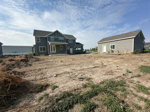 Back of property with a patio and roof with shingles