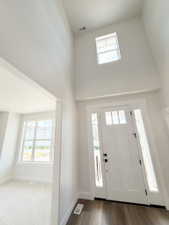 Two-story foyer with a transom window and a contemporary white front door with sidelights