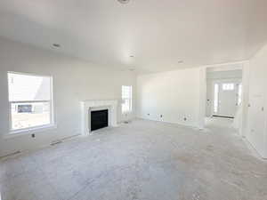 Unfurnished living room featuring healthy amount of natural light and a fireplace