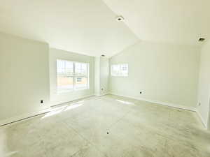 Unfurnished room with baseboards and lofted ceiling