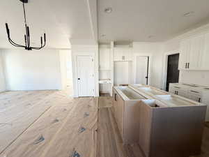 Kitchen with a center island, white cabinetry, and a chandelier