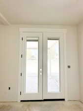 Doorway to outside with french doors and carpet