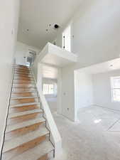 Stairway with healthy amount of natural light and a high ceiling