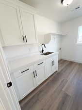 Laundry area featuring dark wood-style floors, hookup for a washing machine, and cabinet space