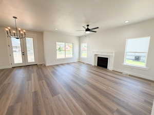 Spacious living area featuring wood-finish flooring, a white mantel fireplace, and recessed lighting