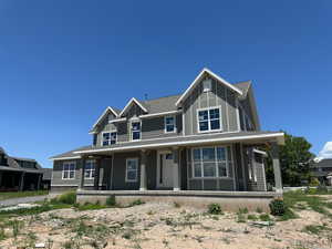 View of front facade featuring covered porch and a shingled roof