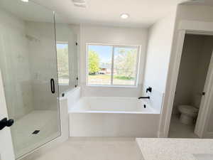 Contemporary bathroom featuring a spacious soaking tub, separate glass-enclosed shower with tile surround, and a window providing exterior views