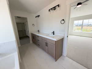 Contemporary bathroom featuring a double vanity with stone countertops and undermount sinks, matte black fixtures, modern light fixtures, and white tile flooring