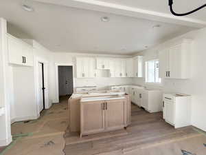 Kitchen with a center island, white cabinets, and recessed lighting
