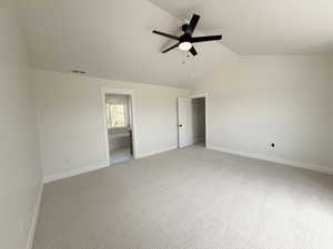 Spacious room featuring vaulted ceilings, a contemporary ceiling fan, and light-colored carpeting