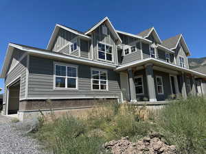 View of front facade with board and batten siding and an attached garage